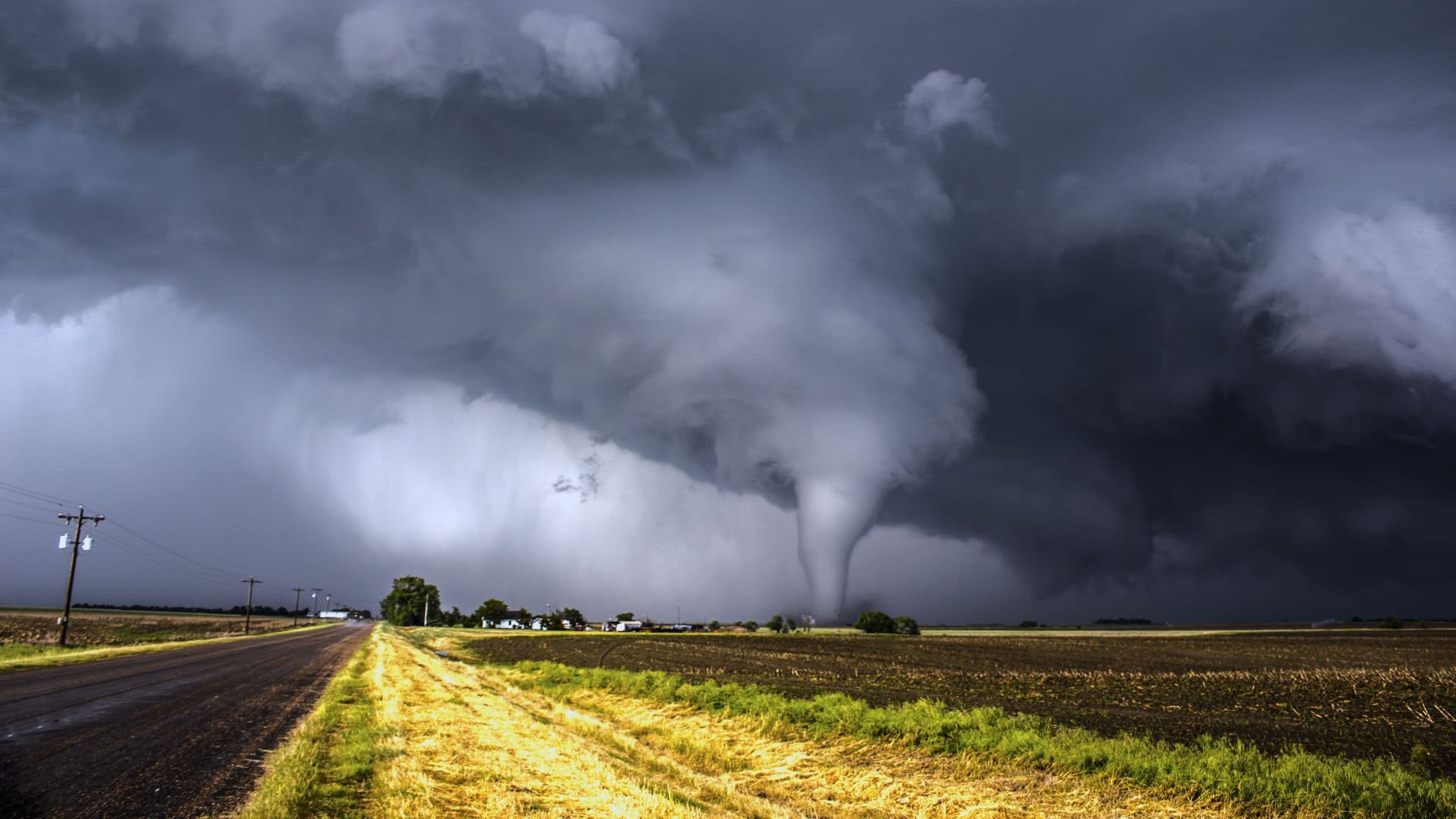 a tornado in a field with a road running alongside